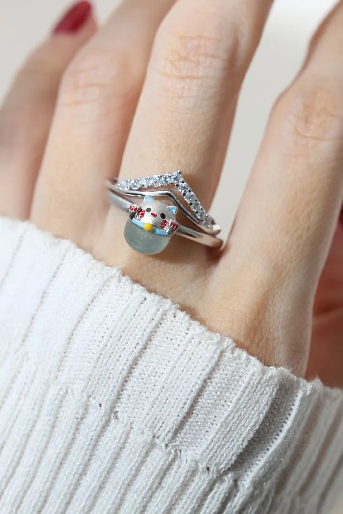 A model wearing the whimsical Fortune Cat ring crafted in silver, featuring a vibrant blue chalcedony gemstone. The adorable Maneki-neko design symbolizes luck and positivity, perfect for adding charm to any outfit.