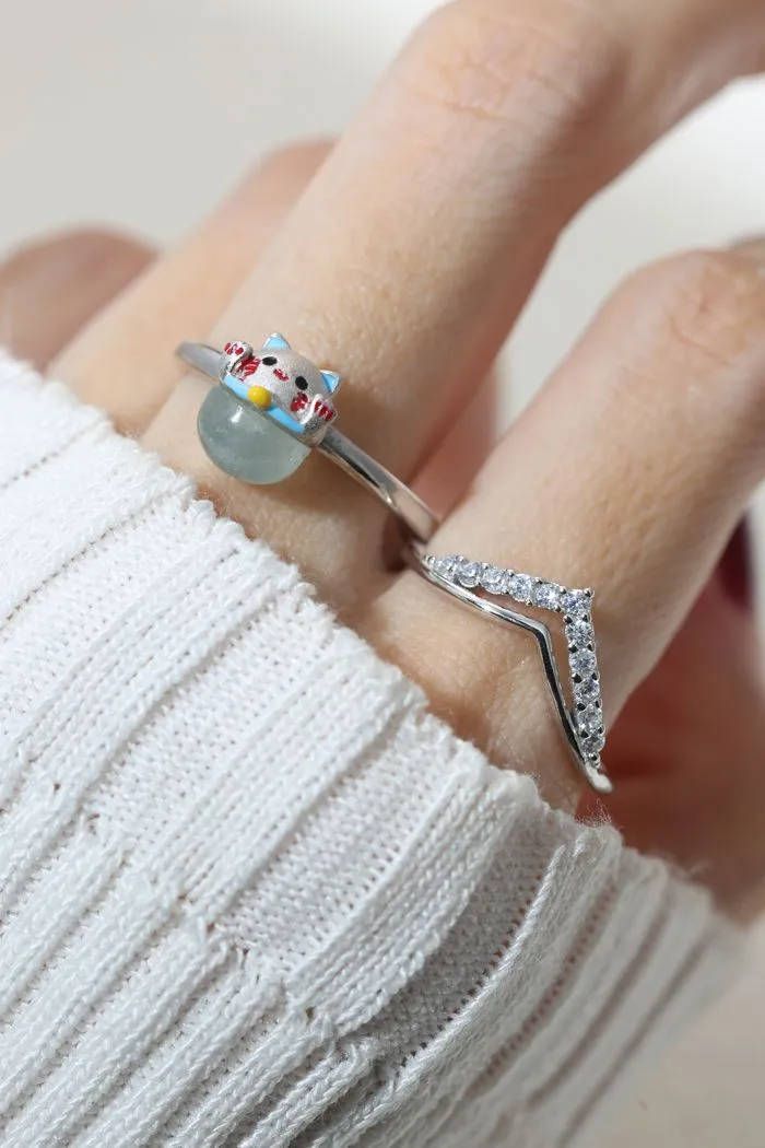 A model wearing the whimsical Fortune Cat ring crafted in silver, featuring a vibrant blue chalcedony gemstone. The adorable Maneki-neko design symbolizes luck and positivity, perfect for adding charm to any outfit.