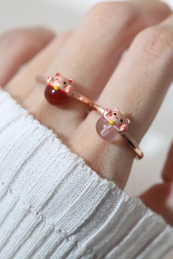 A model wearing the Fortune cat ring crafted in rose gold, featuring a playful cat motif resting on a polished rose quartz gemstone, symbolizing luck and positivity.