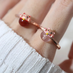 A model wearing the Fortune cat ring crafted in rose gold, featuring a playful cat motif resting on a polished rose quartz gemstone, symbolizing luck and positivity.