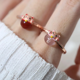 A model wearing the Fortune cat ring crafted in rose gold, featuring a playful cat motif resting on a polished rose quartz gemstone, symbolizing luck and positivity.