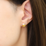 A model wearing the fortune cat-inspired studs featuring adorable feline motifs, elegantly perched on polished tiger eye gemstones for a touch of charm and good fortune.