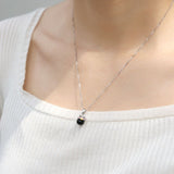 Fortune Cat Necklace (Obsidian) in silver, worn on a model