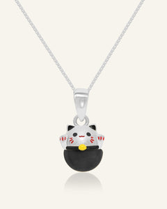 Fortune Cat Necklace (Obsidian) in silver, resting on a warm linen background