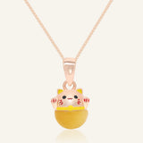 Fortune Cat Necklace (Tiger Eye) in rose gold, resting on a warm linen background