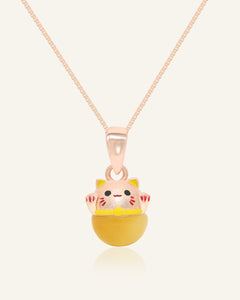 Fortune Cat Necklace (Tiger Eye) in rose gold, resting on a warm linen background