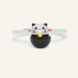 Fortune Cat Ring (Obsidian) in silver, resting on a warm linen background