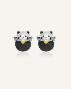 Fortune Cat Studs (Obsidian) in silver, resting on a warm linen background