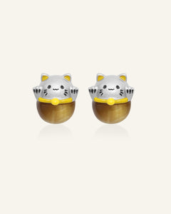 Fortune Cat Studs (Tiger Eye) in silver, resting on a warm linen background