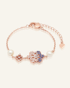 Close-up of the Frosted Snowflake Pearl Bracelet in rose gold, resting on a warm linen background