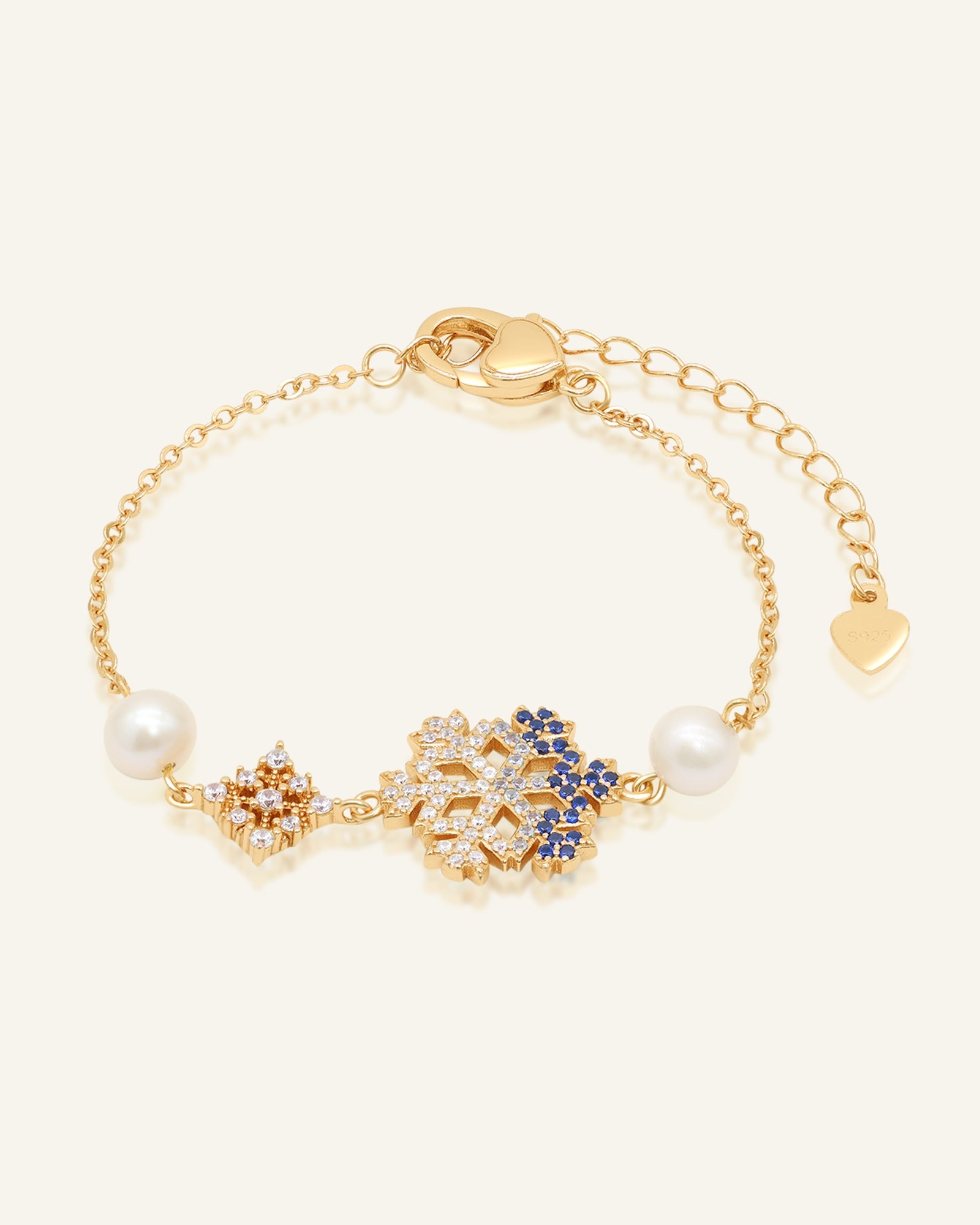 Frosted Snowflake Pearl Bracelet in yellow gold, resting on a warm linen background