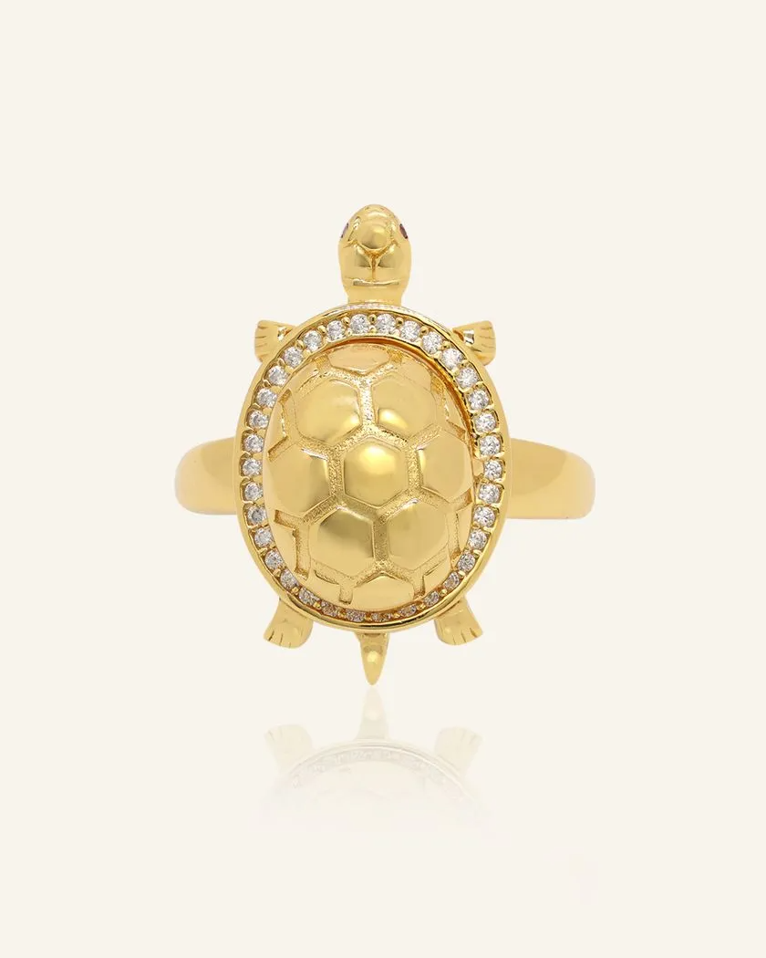 feng shui Golden turtle ring with a hinged shell that opens to reveal a vibrant oval citrine gemstone at its center, surrounded by a sparkling halo of white stones, set in a yellow gold band
