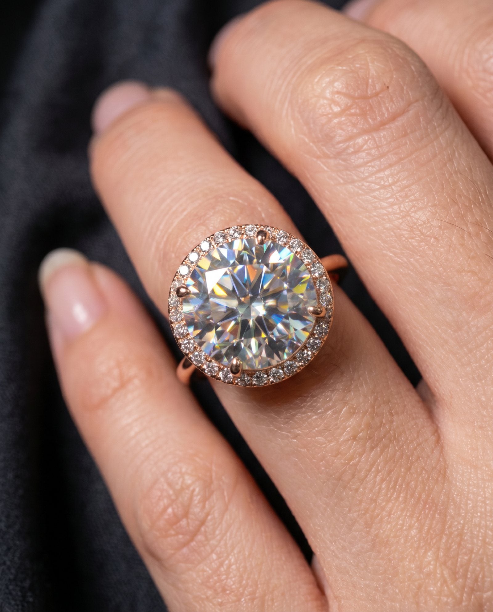 Close-up view of Grand Halo Ring in Rose Gold on hand, showcasing the fire and brilliance of the 3-carat center stone.