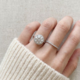 Grand Halo Ring in Silver styled on hand next to a wedding band to show a realistic engagement and anniversary stack.