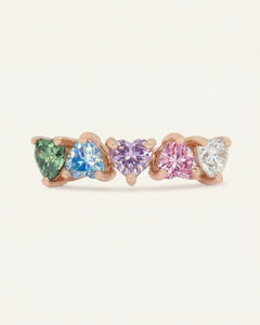 Close-up of the Eternity Heart Band | Pastel Rainbow, Elate in rose gold, resting on a warm linen background