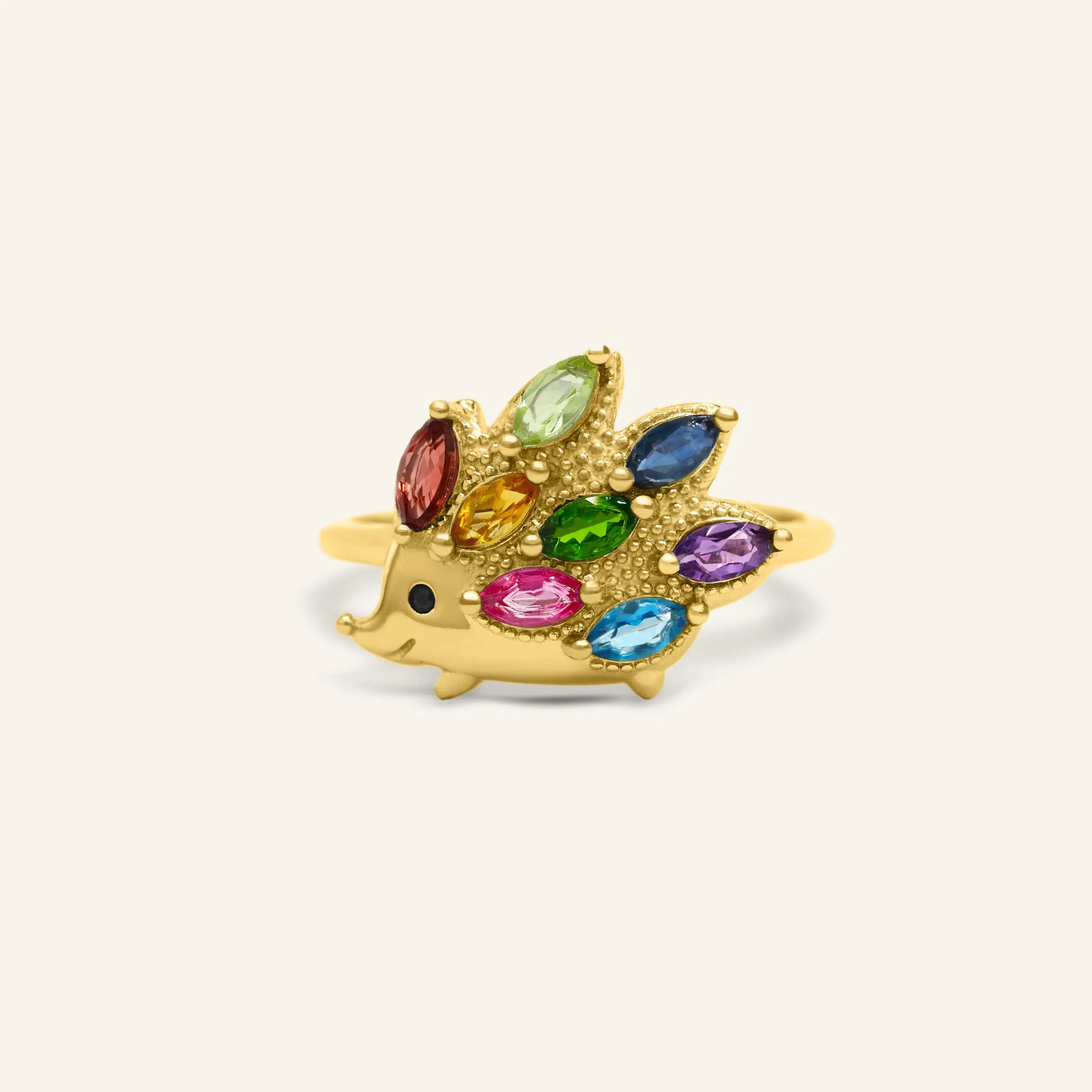 Close-up of a yellow gold hedgehog ring set with natural gemstones
