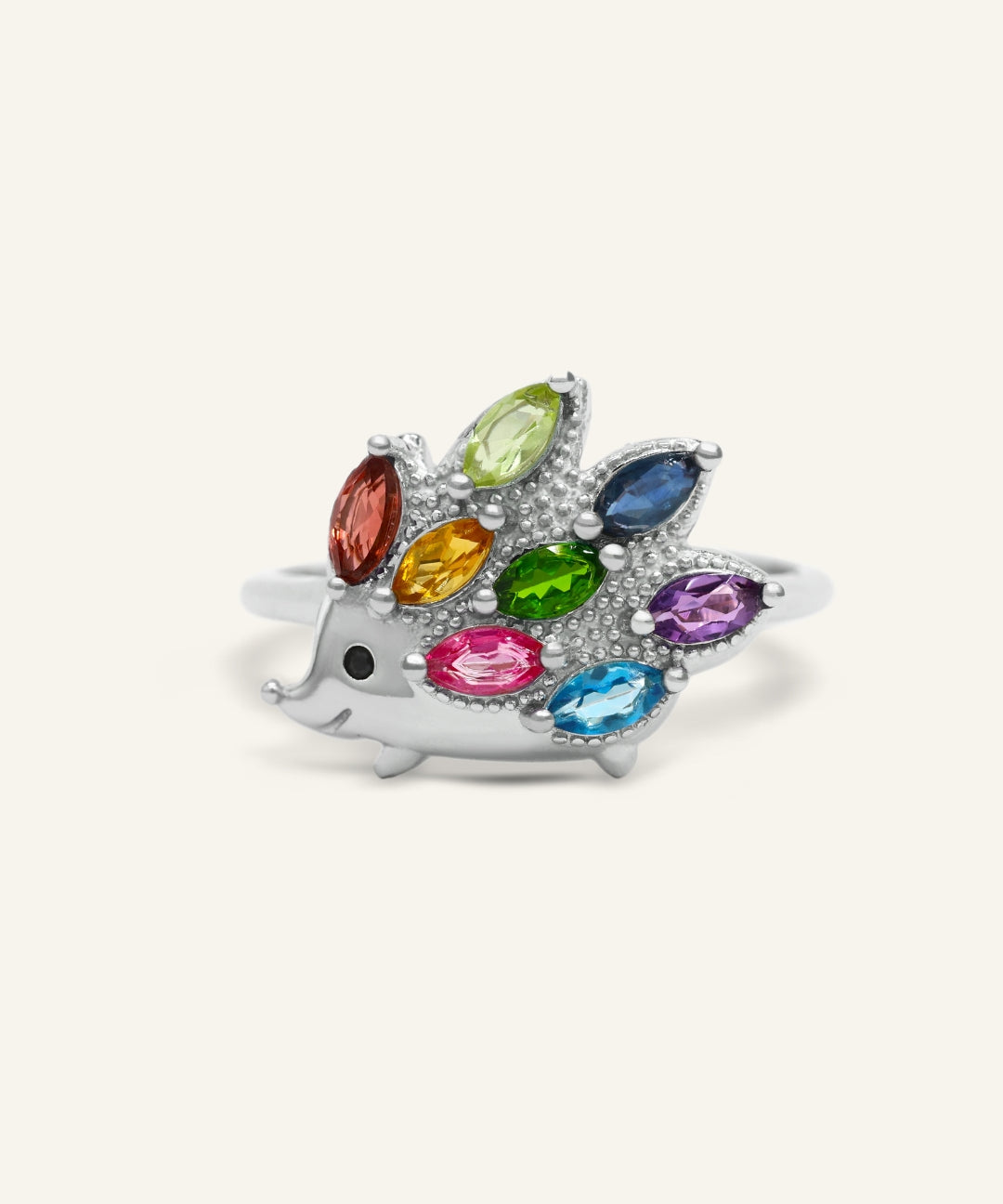 Hedgehog Ring (Multi-Gemstones) in silver, resting on a warm linen background