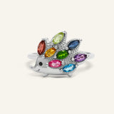 Hedgehog Ring (Multi-Gemstones) in silver, resting on a warm linen background