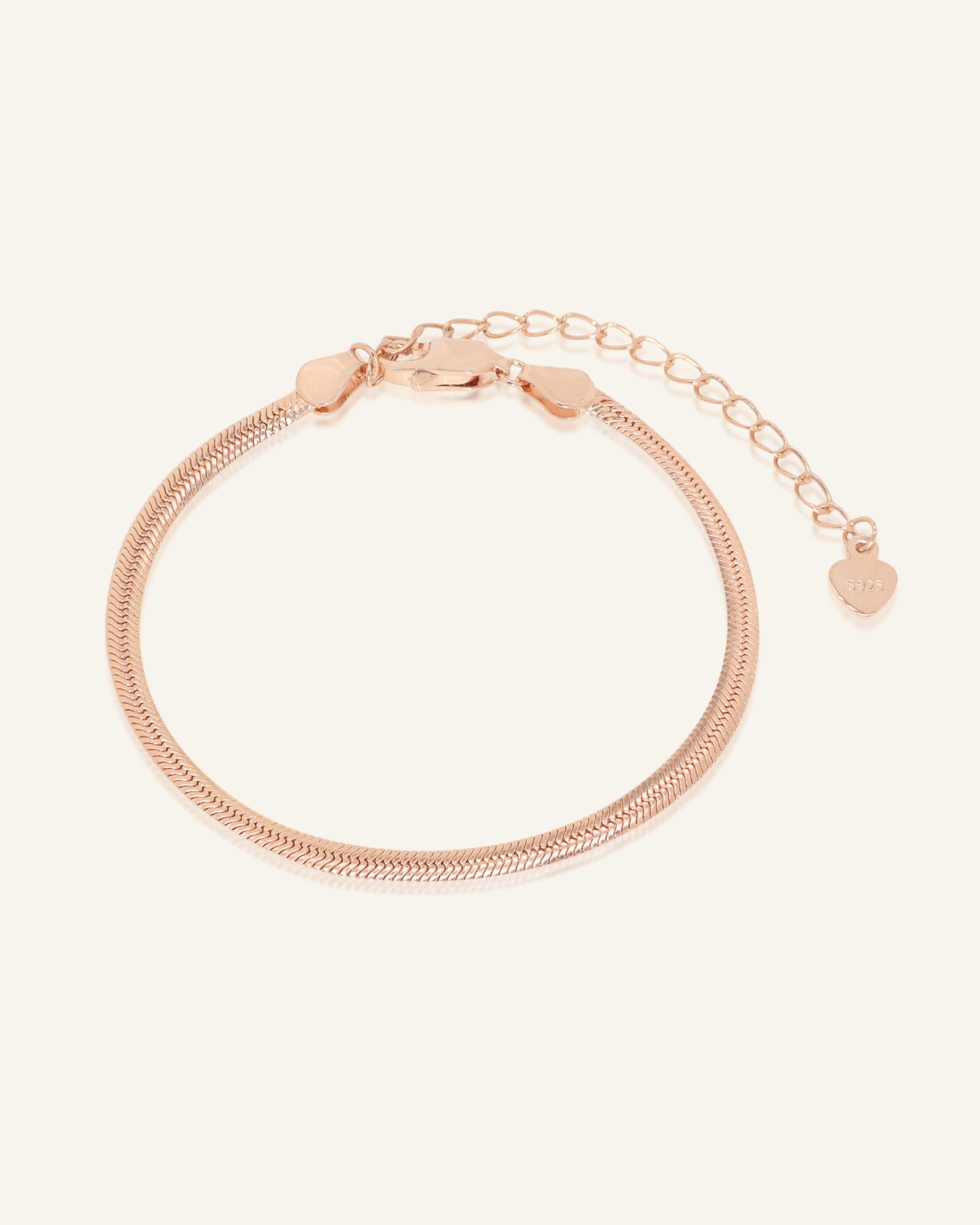 Herringbone Bracelet | Elate in rose gold, resting on a warm linen background