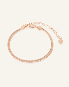 Herringbone Bracelet | Elate in rose gold, resting on a warm linen background