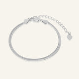 Close-up of the Herringbone Bracelet | Elate in silver, resting on a warm linen background