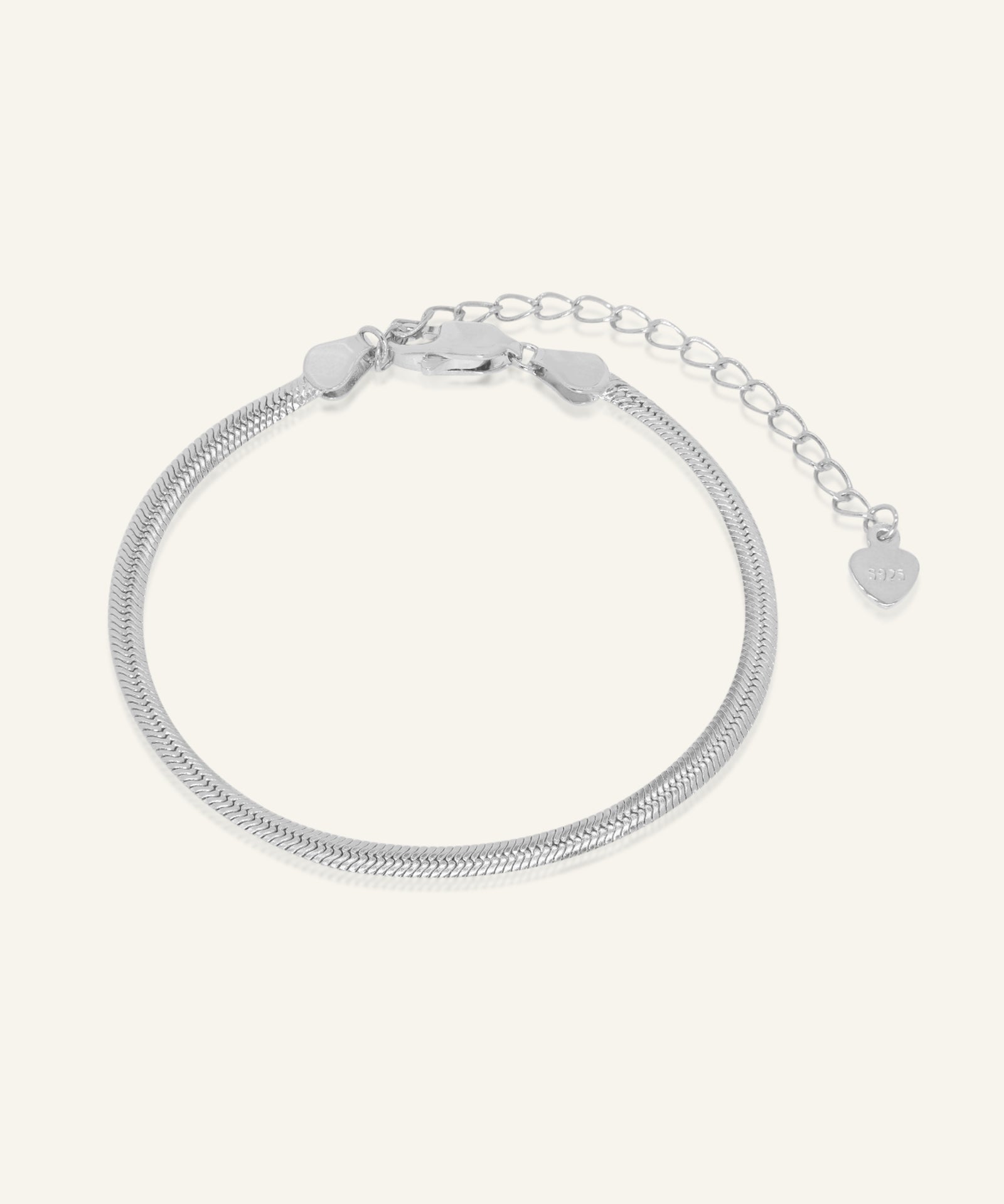 Close-up of the Herringbone Bracelet | Elate in silver, resting on a warm linen background
