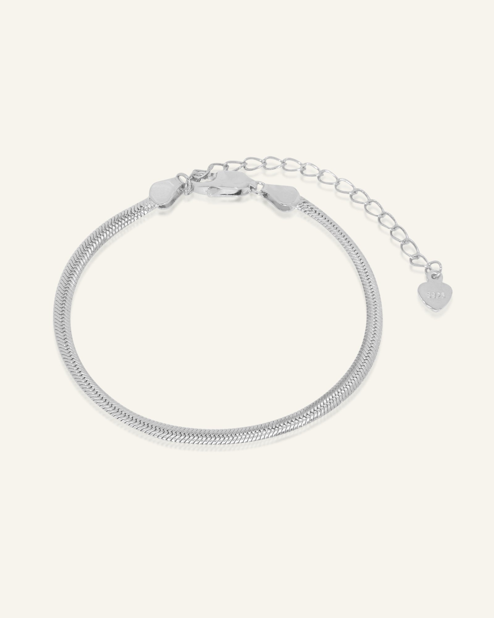 Close-up of the Herringbone Bracelet | Elate in silver, resting on a warm linen background