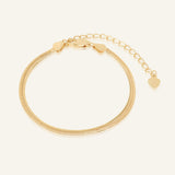 Herringbone Bracelet | Elate in yellow gold, resting on a warm linen background