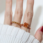 A model wearing the rose gold Huat Kueh-inspired ring featuring a vibrant citrine gemstone as the steamed cake centerpiece, adorned with intricate enamel details, including 'Huat' and floral accents symbolizing prosperity and joy.