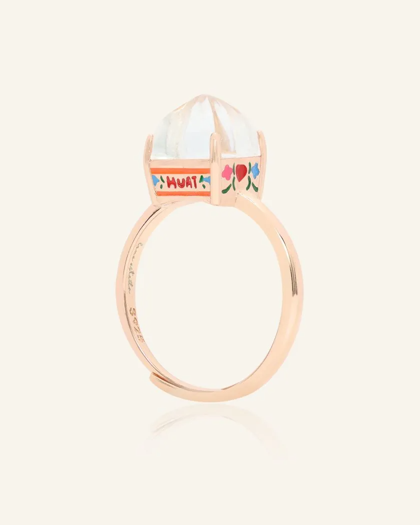 A rose gold Huat Kueh-inspired ring set with a dome-shaped white topaz centerpiece, featuring intricate hand-painted details of vibrant flowers and the word "HUAT" on the band, symbolizing prosperity and good fortune.