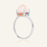 Huat Kueh Ring (Rose Quartz) in yellow gold, resting on a warm linen background
