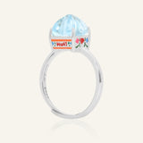 Close-up of the Huat Kueh Ring (Sky Blue Topaz) in silver, resting on a warm linen background