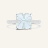 Huat Kueh Ring (Sky Blue Topaz) in silver, resting on a warm linen background, additional angle