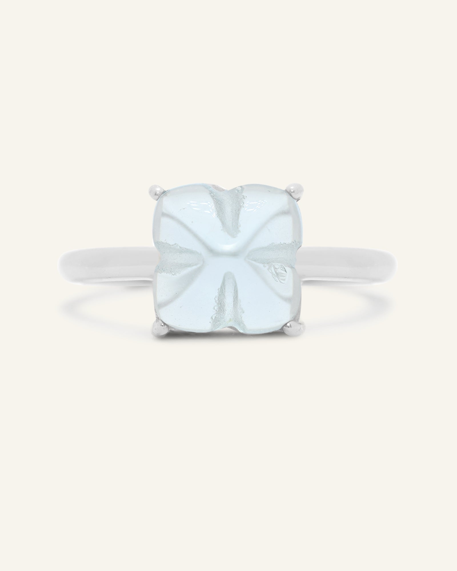 Huat Kueh Ring (Sky Blue Topaz) in silver, resting on a warm linen background, additional angle
