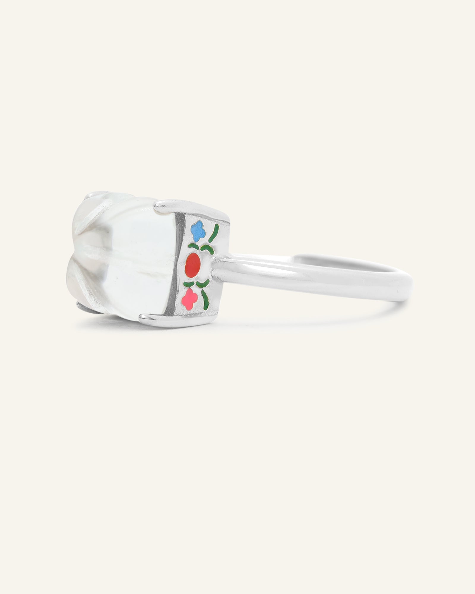Huat Kueh Ring (White Topaz) in silver, resting on a warm linen background