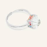 Huat Kueh Ring (White Topaz) in silver, resting on a warm linen background, alternate angle