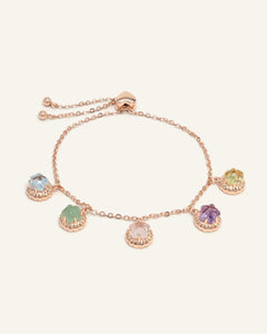 Ice Gem Biscuit Charm Slider Bracelet in rose gold, resting on a warm linen background