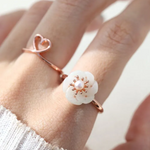 Rose gold jadeite knot ring worn on the finger, highlighting its subtle green hue and intricate knot design.		