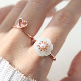 Rose gold jadeite knot ring worn on the finger, highlighting its subtle green hue and intricate knot design.		