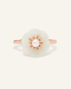 Close-up of the Jadeite Knot Ring in rose gold, resting on a warm linen background