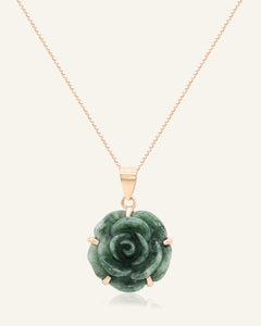 Close-up of the Jadeite Rose Necklace in rose gold, resting on a warm linen background