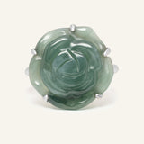 Jadeite Rose Ring in silver, resting on a warm linen background