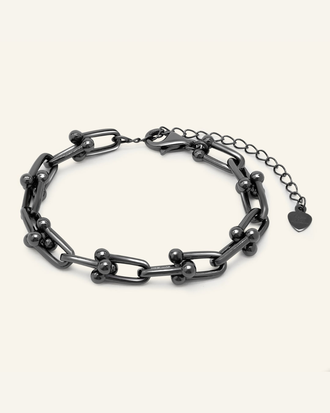 Lock Link Bracelet | Elate in black gold, resting on a warm linen background