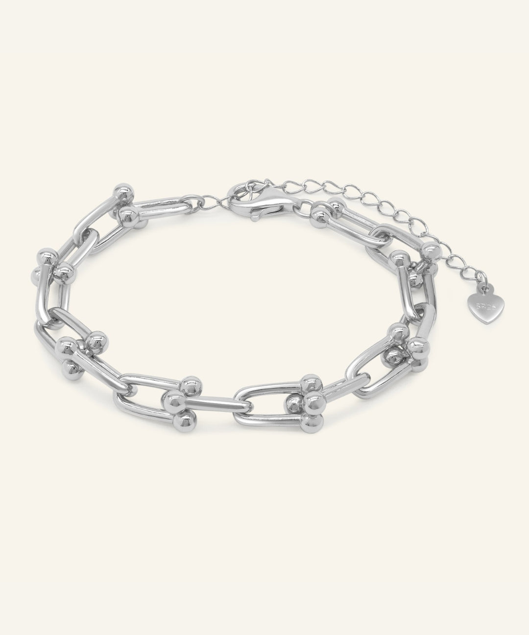 Close-up of the Lock Link Bracelet | Elate in silver, resting on a warm linen background