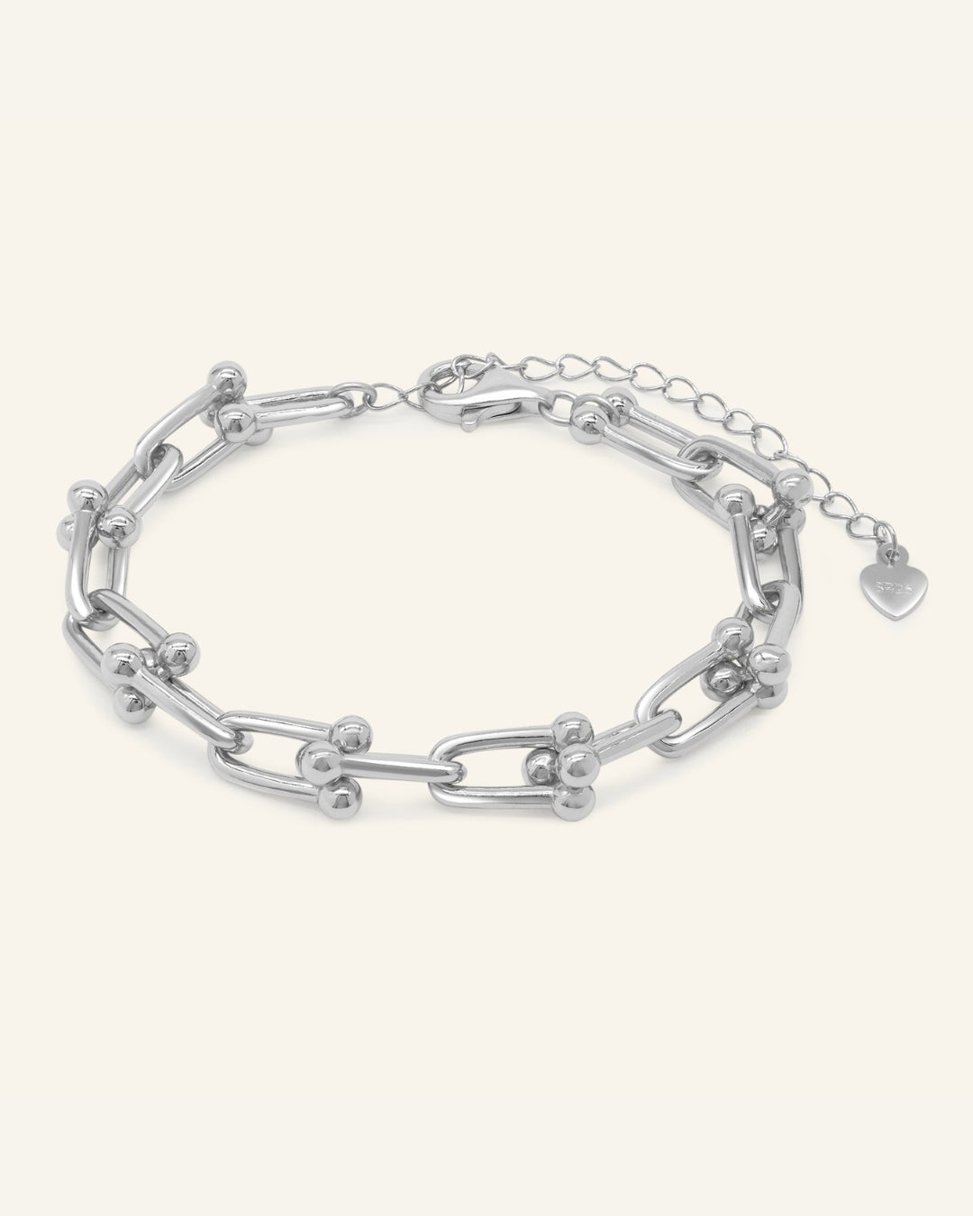 Close-up of the Lock Link Bracelet | Elate in silver, resting on a warm linen background