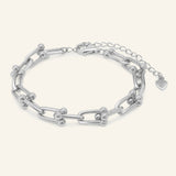 Close-up of the Lock Link Bracelet | Elate in silver, resting on a warm linen background