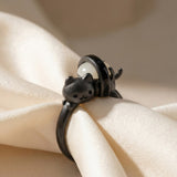Maki Meow Sushi Ring | White Jade in black gold, laid flat on a tabletop