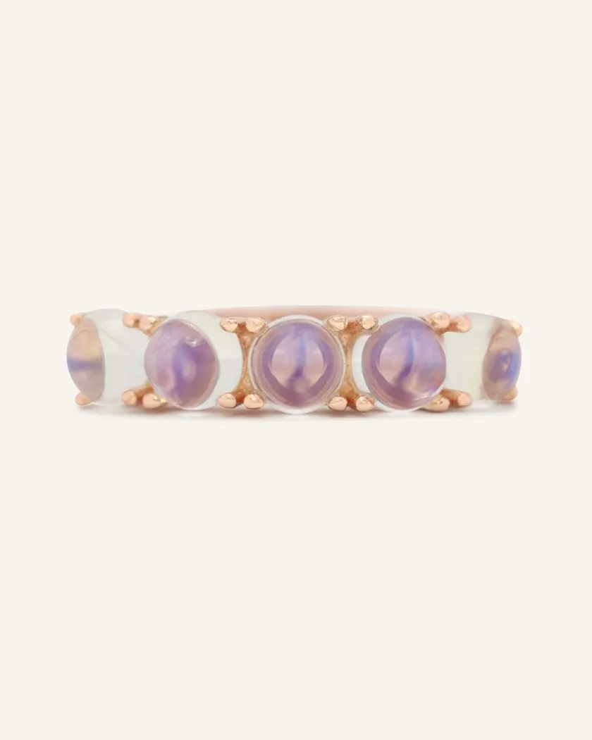 A rose gold band adorned with five round, translucent moonstones, each showcasing a beautiful blend of blue hues.