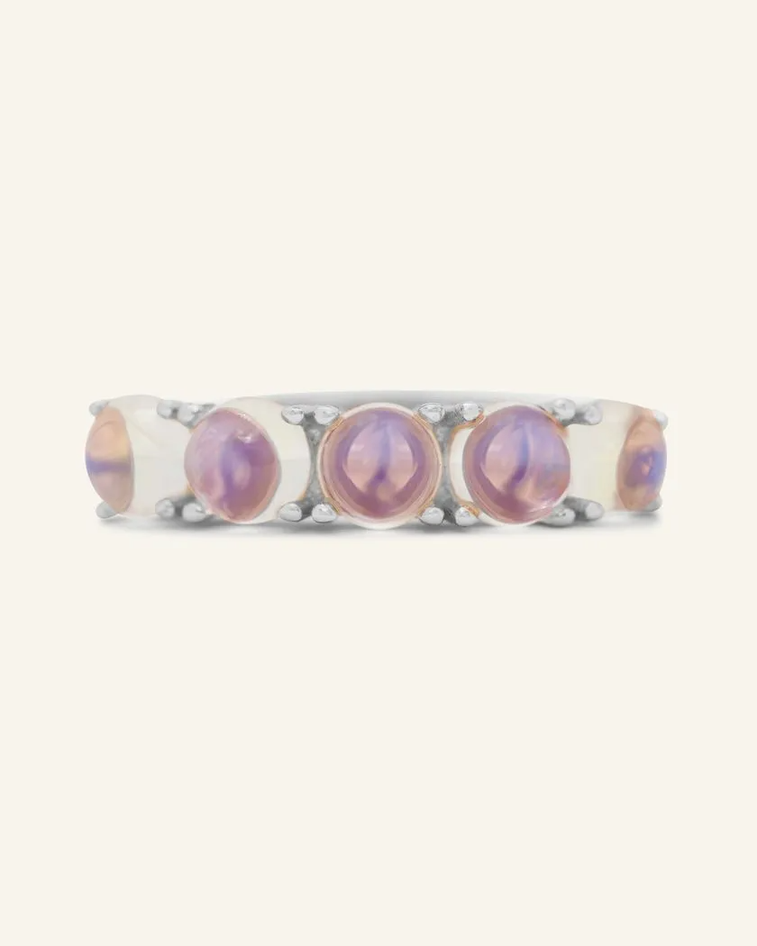 A silver band adorned with five round, translucent moonstones, each showcasing a beautiful blend of blue hues.