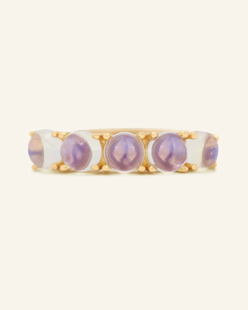 A yellow gold band adorned with five round, translucent moonstones, each showcasing a beautiful blend of blue hues.